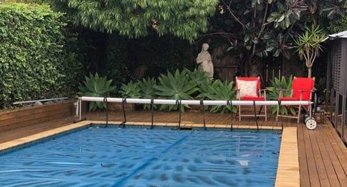Pool Area Swimming pool area with large trees that make it appear smaller and darker. With an ivy wall this all creates a lot of leaf litter.